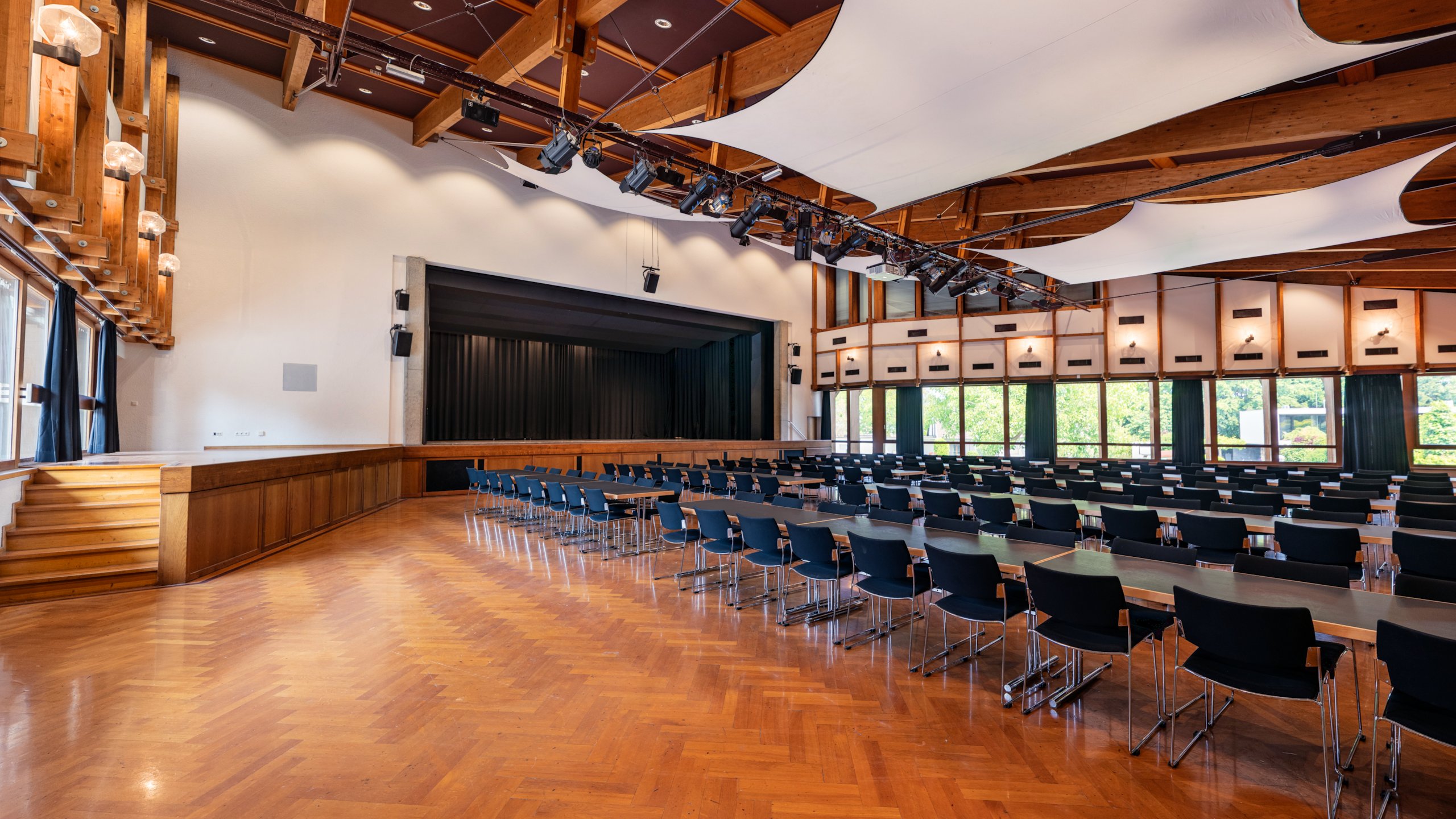 Das Bild zeigt den Großen Saal im Hofsteigsaal in Lauterach mit Reihenbestuhlung und Bühne.