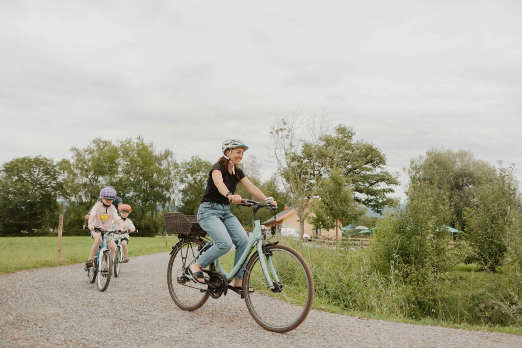 Frau fährt mit Kindern auf dem Fahrrad durch das Lauteracher Ried.