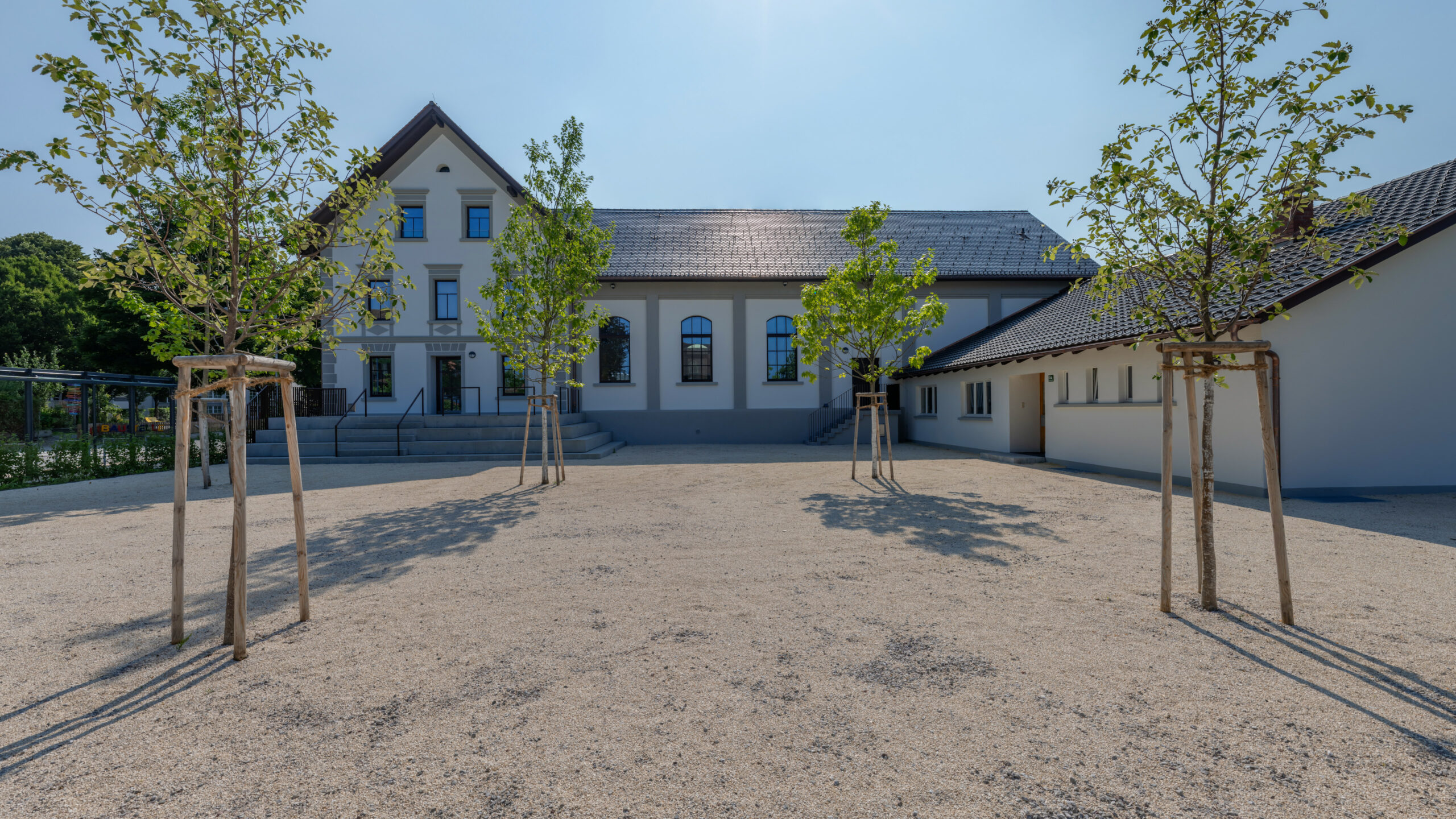 Das Bild zeigt den Park beim Lauteracher Vereinshaus mit Bäumen.