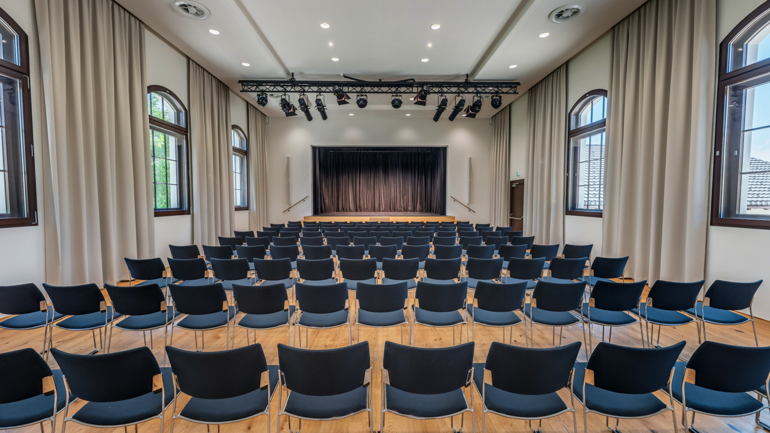 Das Bild zeigt eine Reihenbestuhlung und die Bühne im Saal des Lauteracher Vereinshauses.