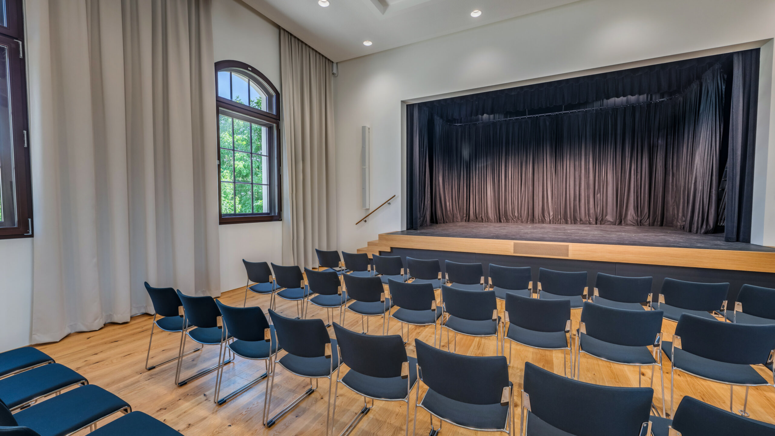 Das Bild zeigt eine Reihenbestuhlung und die Bühne im Saal des Lauteracher Vereinshauses.