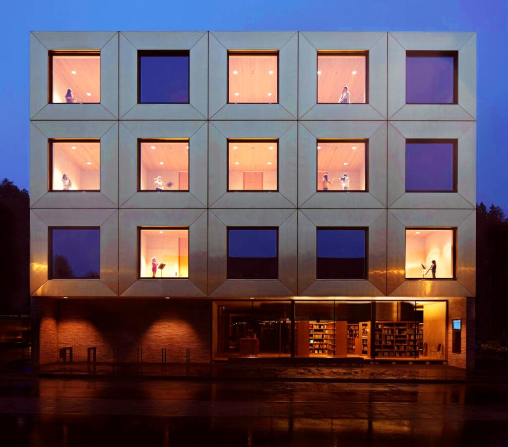 Das Bild zeigt das Gebäude der Musikschule am Hofsteig in Wolfurt beleuchtet am Abend.