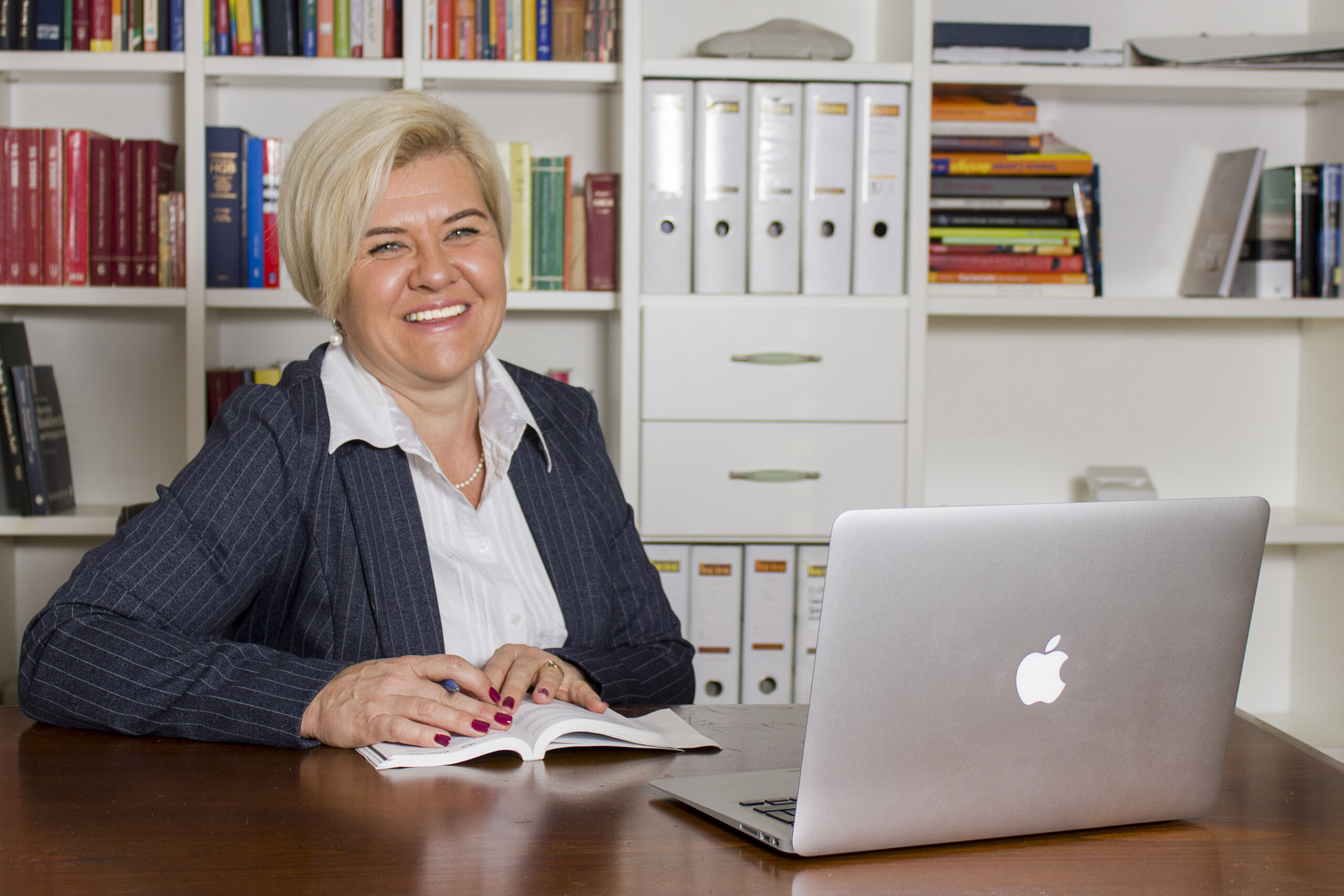 Das Bild zeigt Petra Dressel, die Vorsitzende des Ausschusses für Wohnungswesen der Marktgemeinde Lauterach. Sie sitzt in einem Büro vor einem Computer und lächelt in die Kamera.