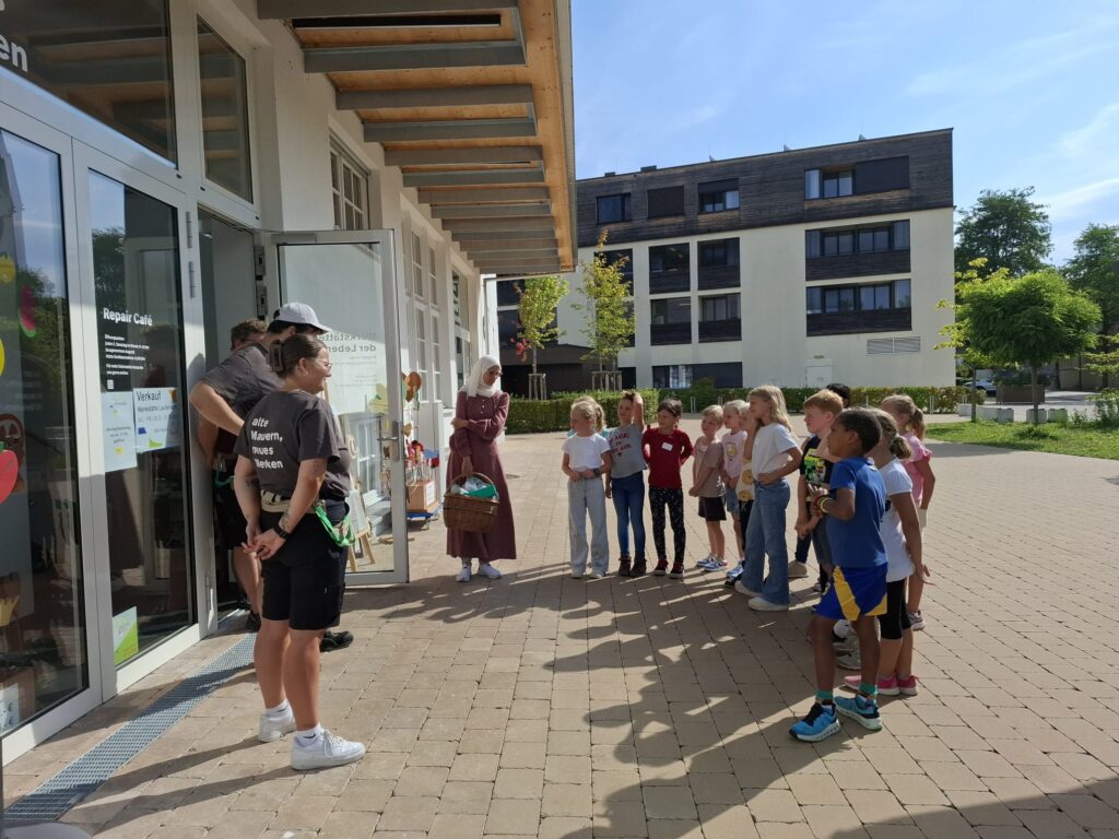 Das Bild zeigt eine Gruppe von Kindern, die vor der Lebenshilfe Werkstätte in Lauterach stehen.
