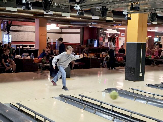 Das Bild zeigt ein Kind beim Bowlen im Bowlingcenter.