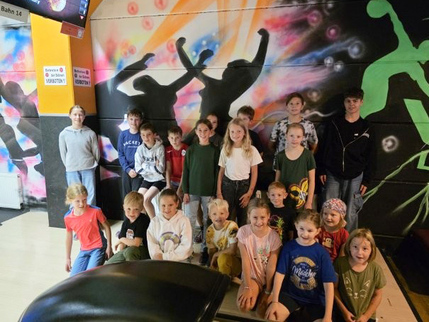 Das Bild zeigt ein Gruppenbild von Kindern im Bowlingcenter.