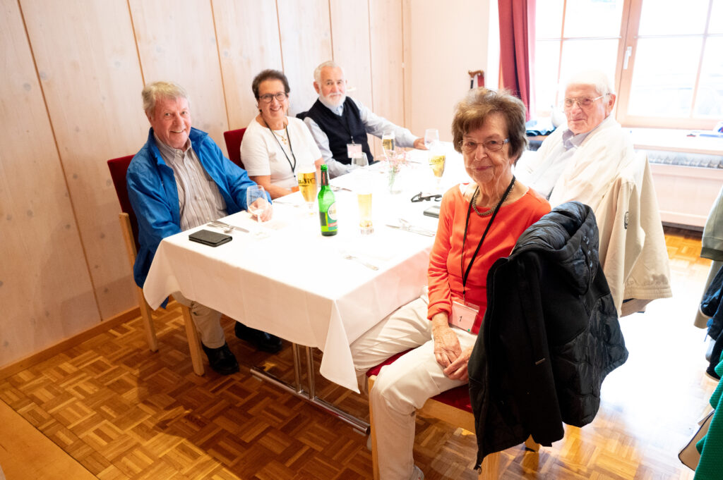Das Bild zeigt fünf Senior:innen an einem Tisch, sie lachen und genießen gemeinsam das Fest.