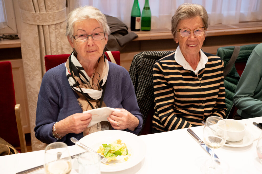 Das Bild zeigt zwei Seniorinnen nebeneinander an einem Tisch, vor ihnen Suppenschalen und Getränke.