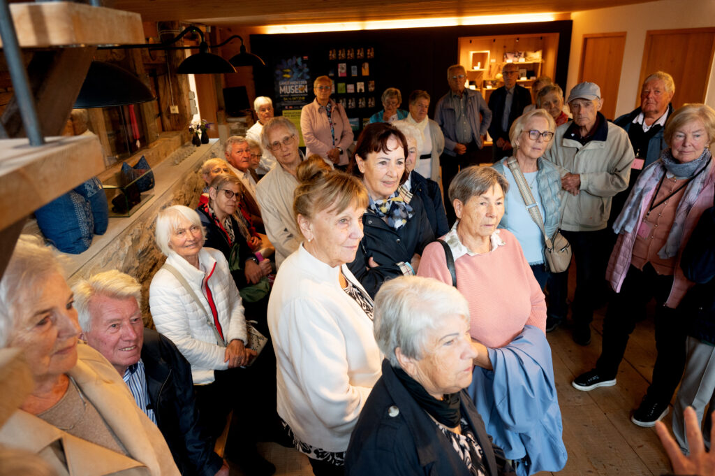 Das Bild zeigt eine große Gruppe Senior:innen bei einer Führung durch die Juppenwerkstatt.