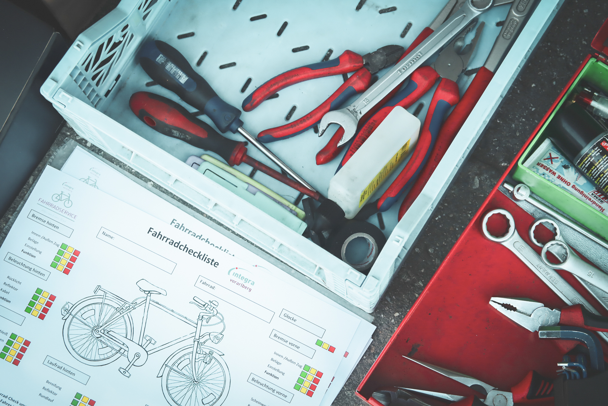 Das Bild zeigt Werkzeug und eine Fahrradcheckliste.