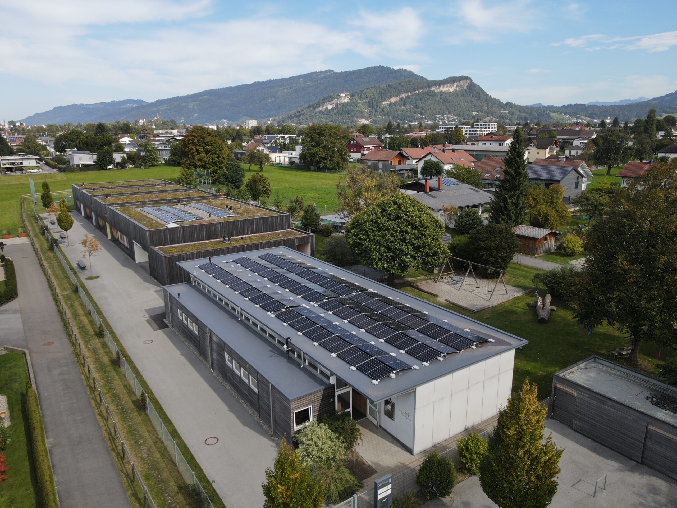 Das Bild zeigt das Dach des Kindergartens Entenbach in Lauterach mit einer PV-Anlage von oben.