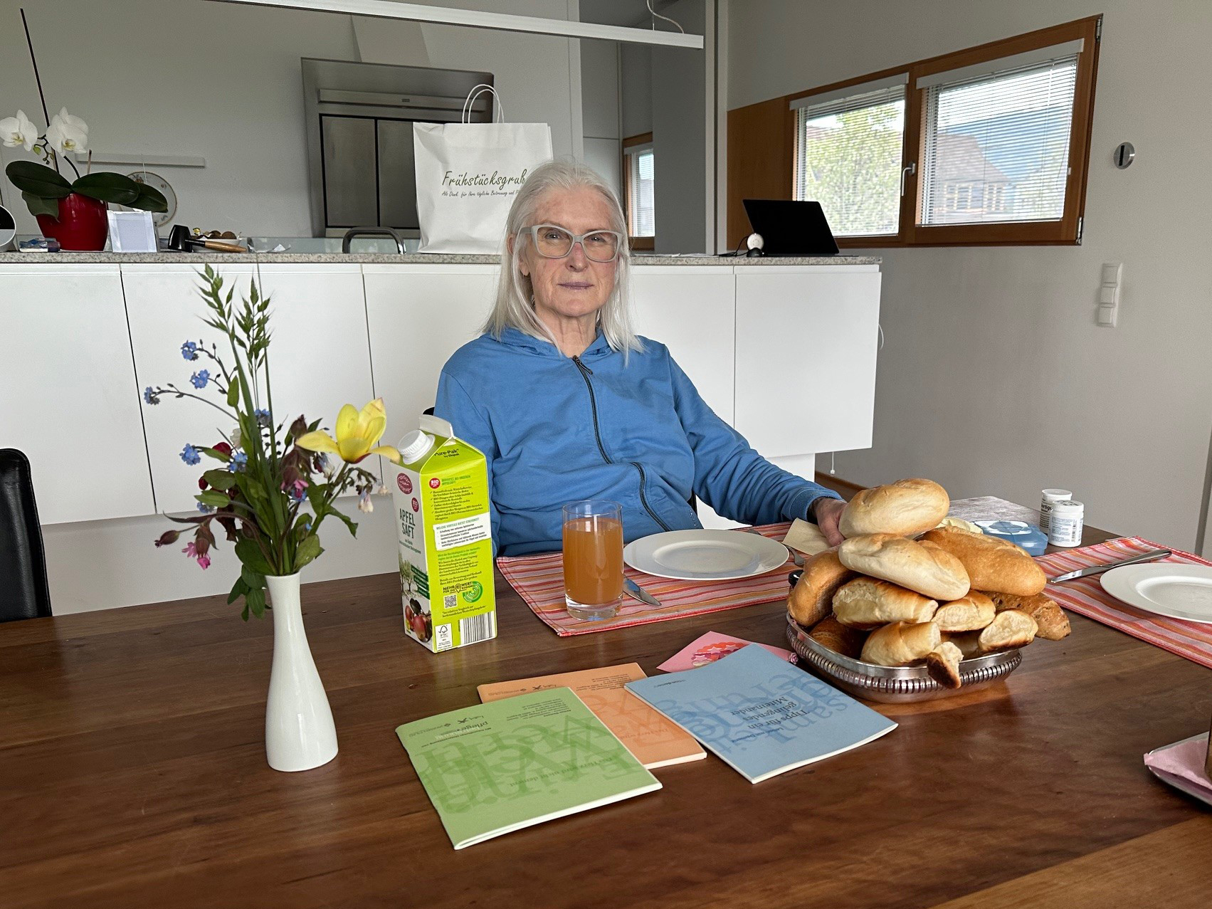 Frühstückstisch mit älterer Dame.