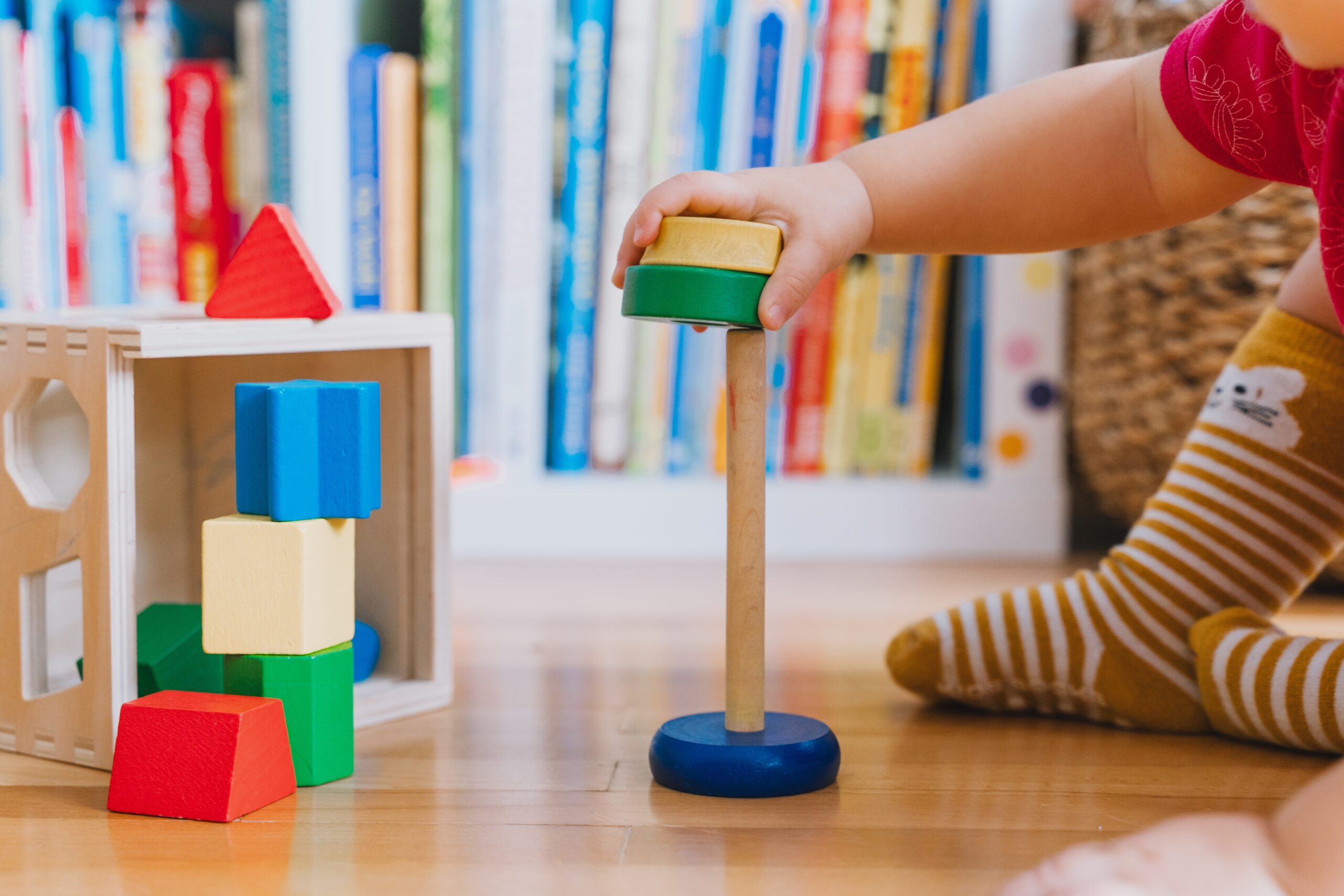 Kind spielt mit bunten Bauklötzen.