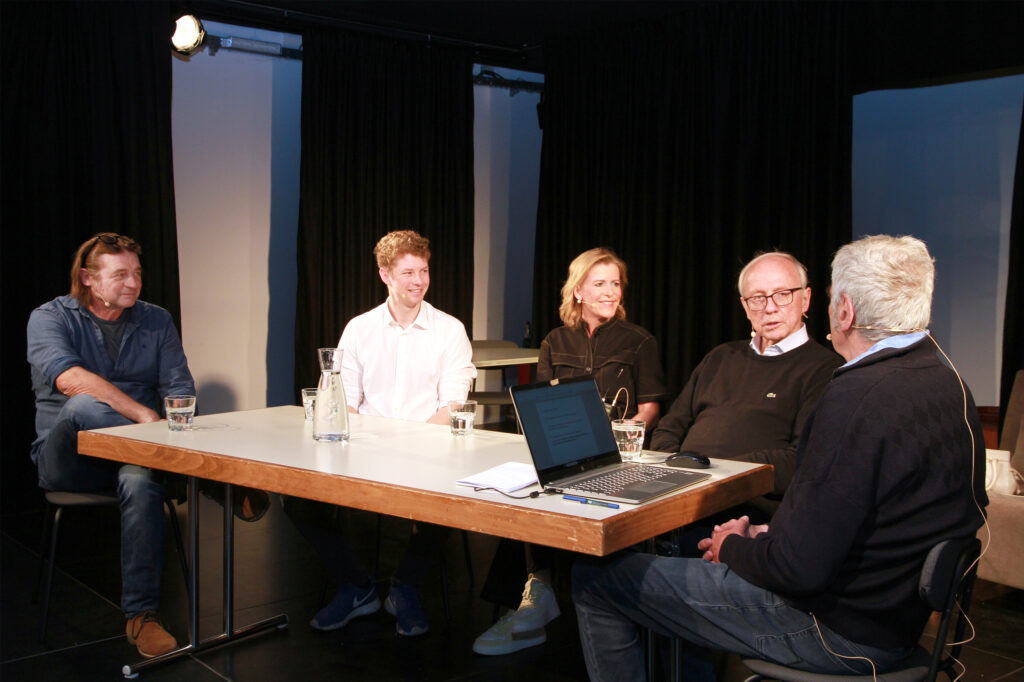 Hannes Einsiedler, Felix Rhomberg, Christine Flatz-Posch, Wolfgang Hilbe und Johannes Schmidle sitzen an einem Tisch und führen ein Gespräch.