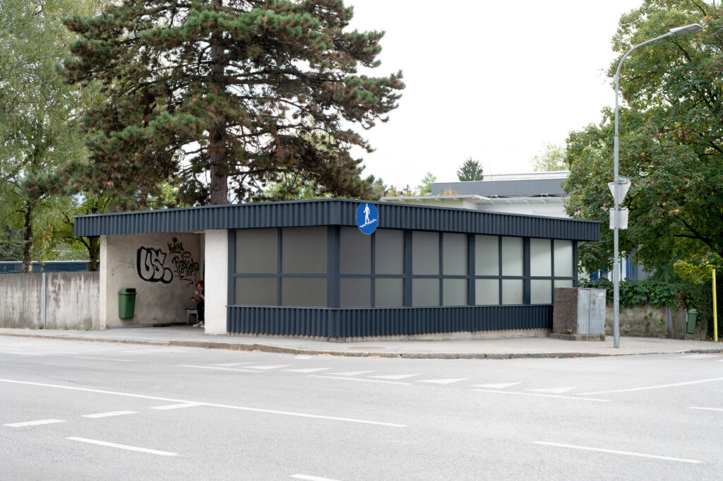 Bushaltestelle mit Fußgänger-Zeichen und Graffiti in Salzburg