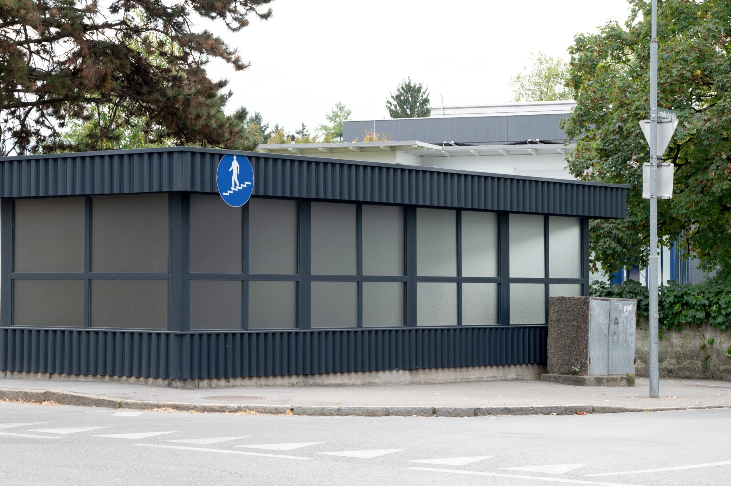 Moderne Unterführung von außen mit großen Fenstern.
