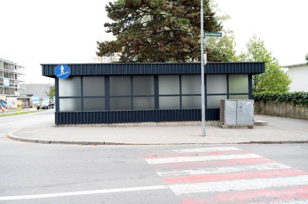 Moderne Haltestelle an der Straße mit Zebrastreifen.