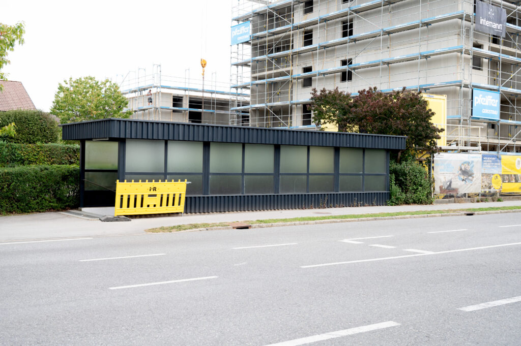 Das moderne Unterführungshaus mit einer Baustelle im Hintergrund und eine Absperrung davor.